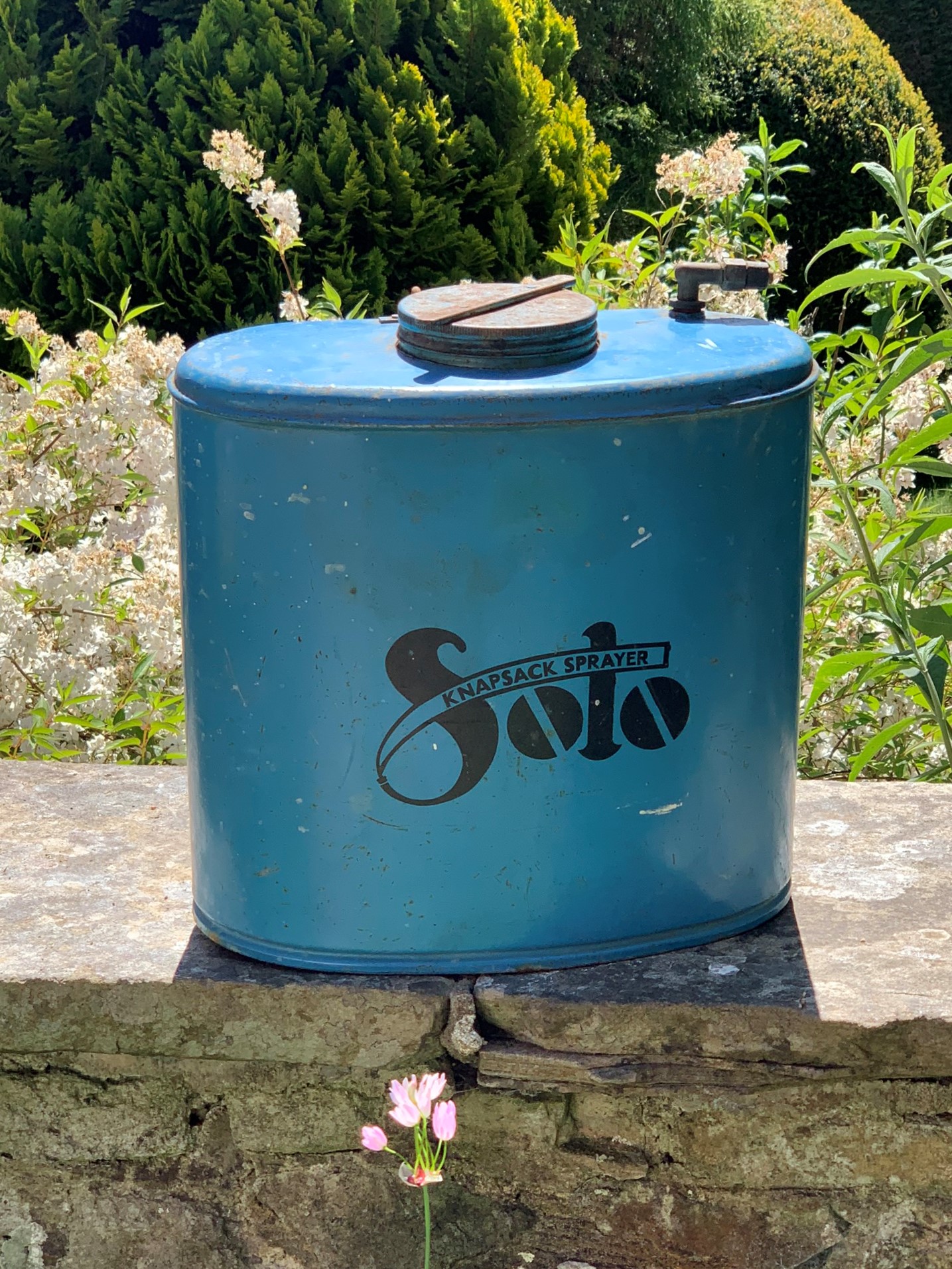A Decorative Blue Metal Knapsack Sprayer With Straps