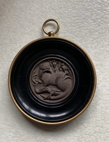 A Miniature Round Otter Wall Plaque By Ceramico