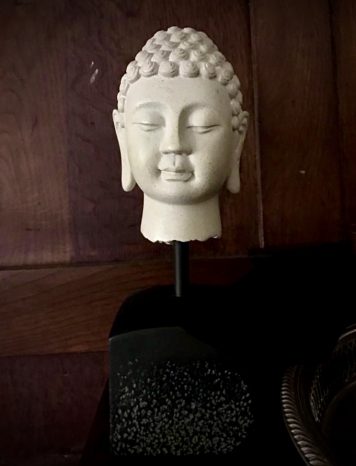 A Carved Stone Effect coloured Buddha Head on Plinth